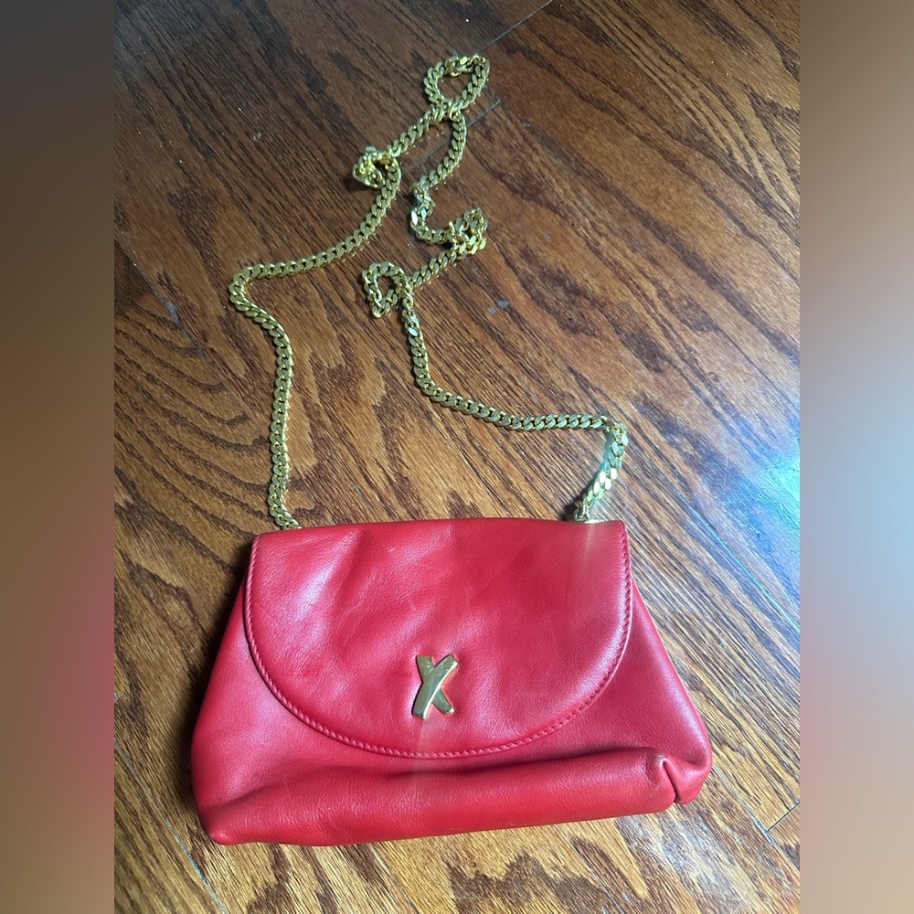 Paloma Picasso red leather crossbody bag a signature gold "X" clasp.